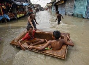 Crianças brincam em banheira durante inundação em Kolkata (Foto: Rupak De Chowdhuri/ Reuters)